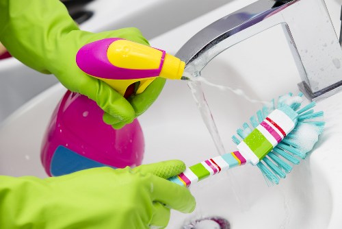 Cleaner applying safe working methods during routine cleaning tasks